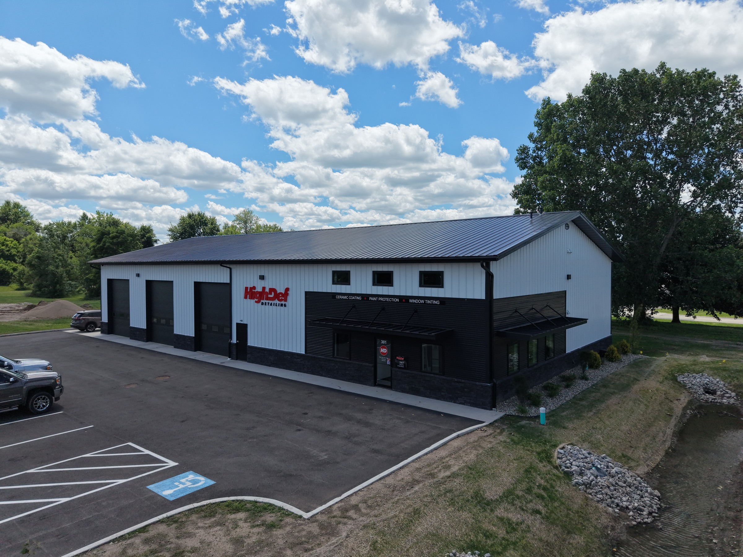 White commercial building with dark roofing, service bays and a customer entrance